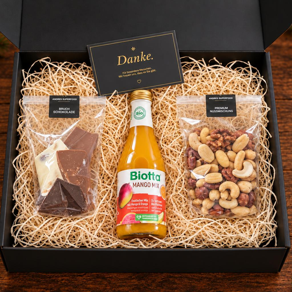 Grosse Geschenkbox von Andre’s Superfood mit Bruchschokolade, Premium-Nussmischung und Biotta Mango Mix – Weihnachtsgeschenk für Mitarbeitende und Kunden.
